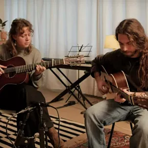 Harris geeft gitaarles op akoestische gitaar